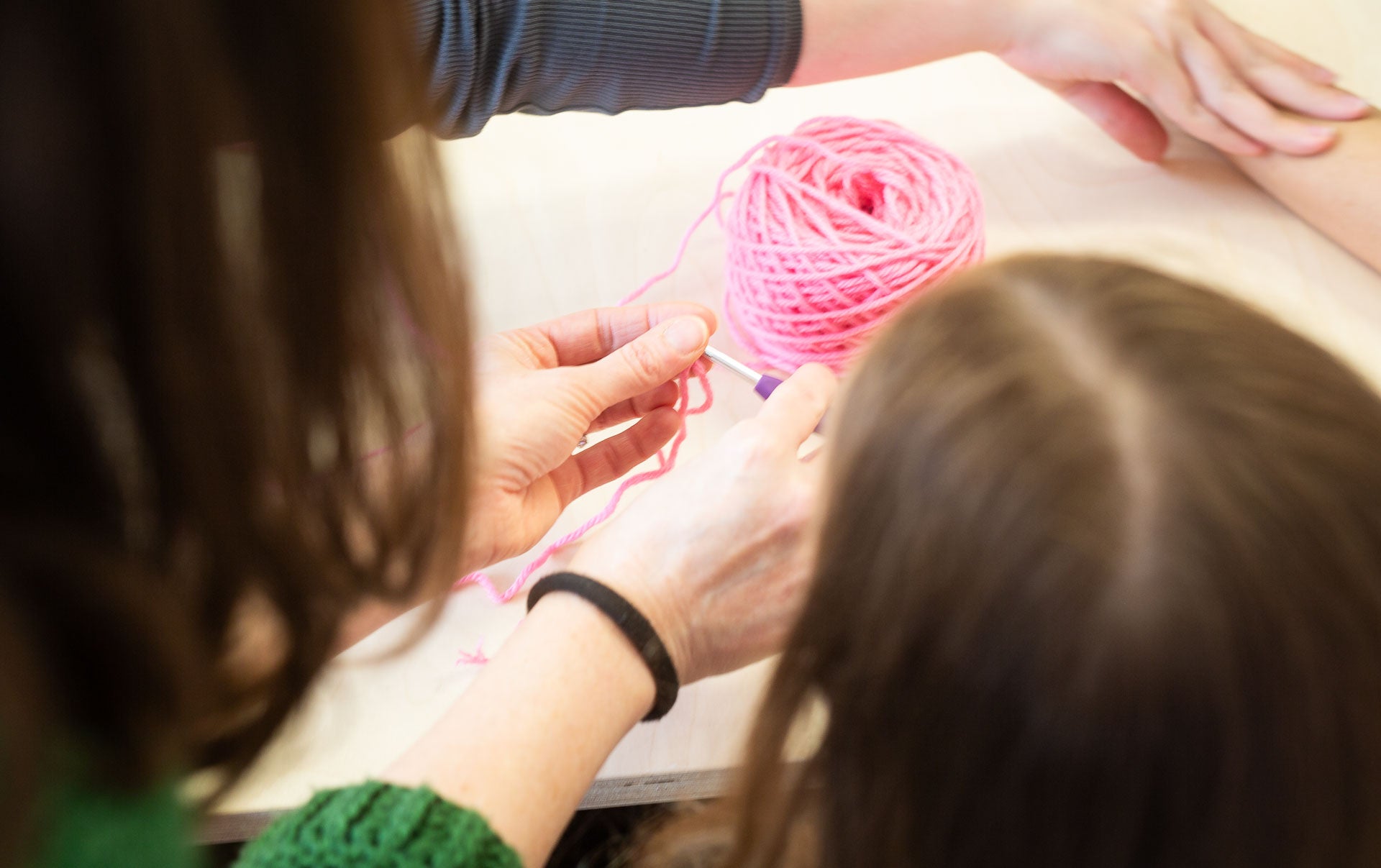 Beginner crochet course at Maker Studio Eastbourne,  small class with tutor Kate McCully teaching adults how to crochet basic stitches, granny squares, circles, and simple projects over four weeks using provided yarn and hooks.