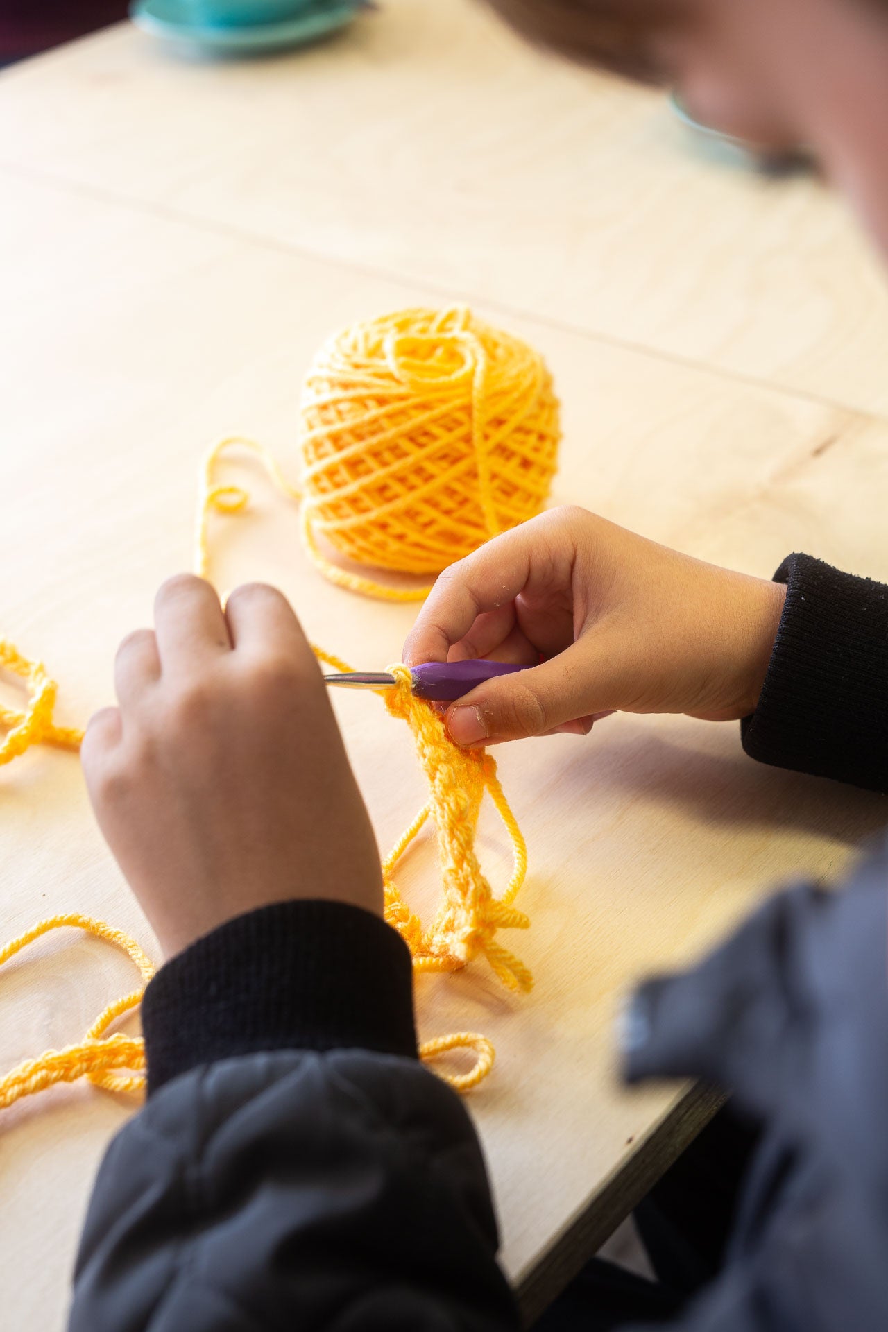 Beginner crochet course at Maker Studio Eastbourne,  small class with tutor Kate McCully teaching adults how to crochet basic stitches, granny squares, circles, and simple projects over four weeks using provided yarn and hooks.
